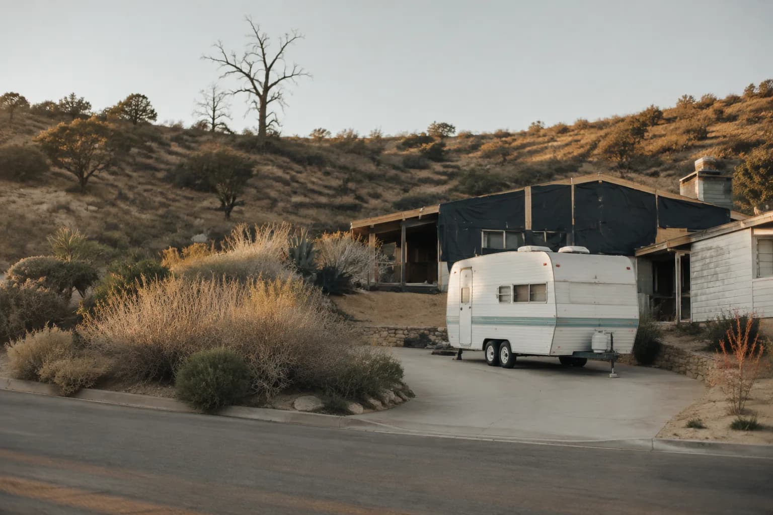 A residential driveway with a travel trailer in California terrain, no landmarks