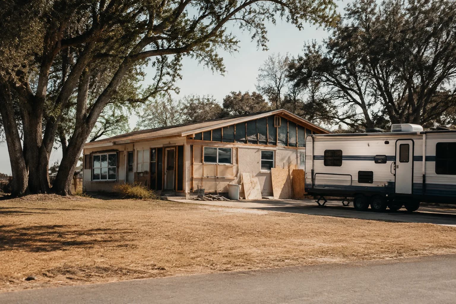 A residential driveway with a travel trailer in Texas terrain, no landmarks